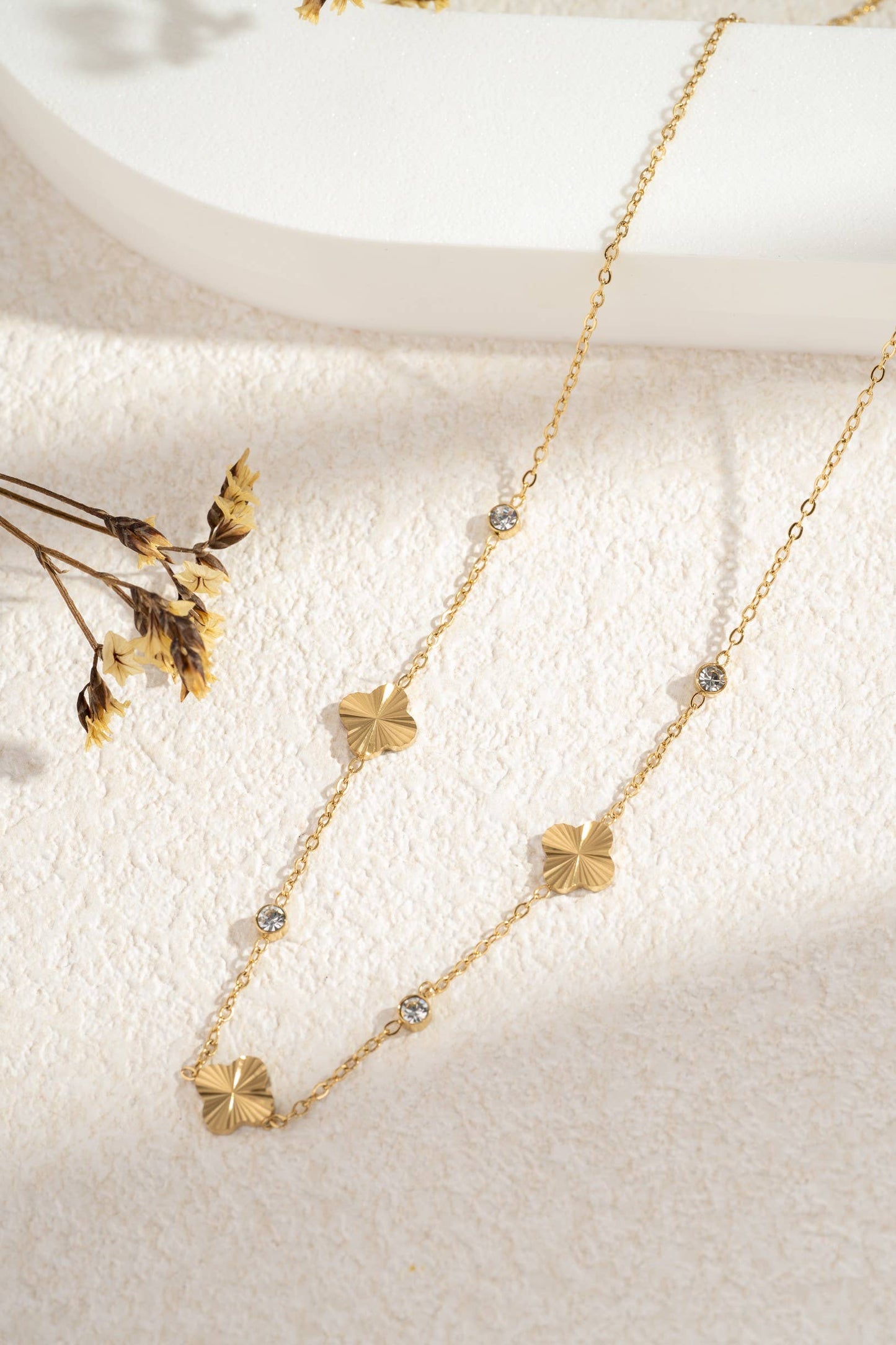 Gouden roestvrijstalen ketting met opengewerkte bloemen en heldere stenen.|Beautiva Boutique