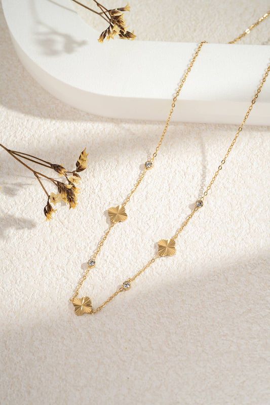Gouden roestvrijstalen ketting met opengewerkte bloemen en heldere stenen.|Beautiva Boutique